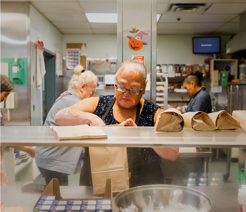 person packing lunches in kitchen